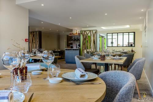 佩罗斯-吉雷克Logis Hôtel du Parc的用餐室配有木桌、椅子和玻璃杯