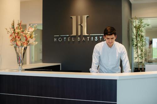 波萨达斯Hotel Batista的站在酒店浴室前台的人