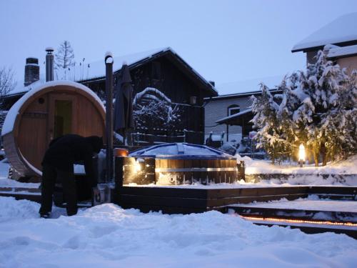 埃尔瓦Purde Puhkemaja - Hot Tub l Sauna l BBQ的站在冰屋前的雪中站着的人