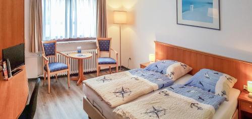 诺德奈Pension Haus Weierts的酒店客房设有两张床和一张桌子。