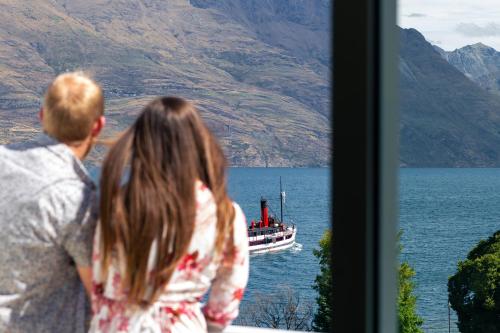 皇后镇皇后镇皇冠假日酒店的水中看船的男人和女孩