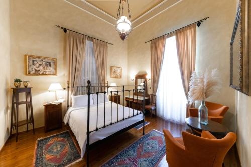 纳夫普利翁那菲斯美顿酒店的卧室配有一张床和一张桌子及椅子