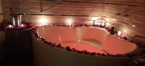 利马秘鲁蒙特瑞科酒店的浴室内设有一个浴缸,周围是红玫瑰