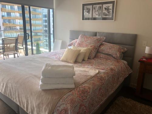 悉尼Modern Spacious City Pad with Rooftop Pool and Gym的一间卧室配有带毛巾的床