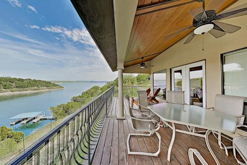 Lago VistaShiraz & Chardonnay Haus的阳台配有桌椅,享有河景