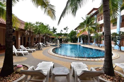 农布Ampan Resort & Apartment的一个带椅子和棕榈树的游泳池的度假酒店