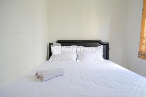 三宝垄Pringgondani Guest House At Pandanaran Hills Semarang的一张带黑色床头板和白色枕头的白色床