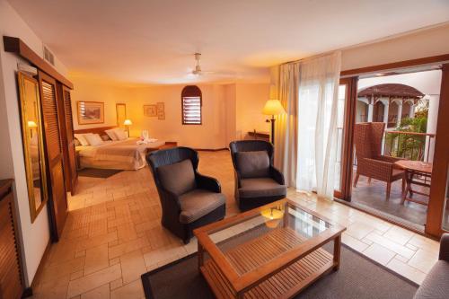 圣吉尔莱班圣亚历克西斯SPA四星酒店的客厅配有椅子、床和桌子