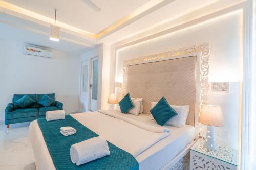 戈阿韦尔哈Lillywoods Zac Beach Resort, Calangute的一间卧室配有一张大床和一张蓝色椅子