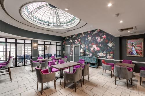 伊夫舍姆The Northwick Arms Hotel的餐厅设有紫色桌椅和玻璃天花板