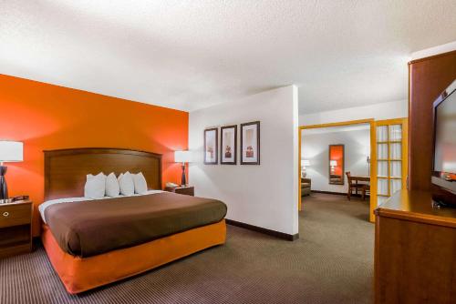 张伯伦AmericInn by Wyndham Chamberlain Conference Center的配有一张床和一台平面电视的酒店客房