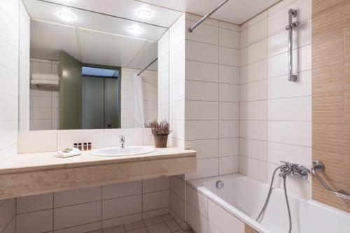 特尔斐德尔福阿玛利亚酒店的一间带水槽、浴缸和镜子的浴室