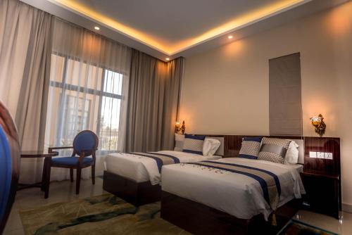 卢萨卡Asmara Hotel的酒店客房,配有两张床和椅子