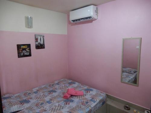 双溪大年LA MOTEL的一间小卧室,配有一张粉红色墙壁的床