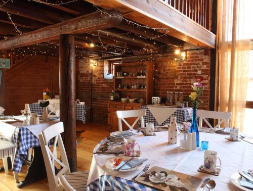 HicklingDairy Barns的一间设有桌椅的用餐室和砖墙