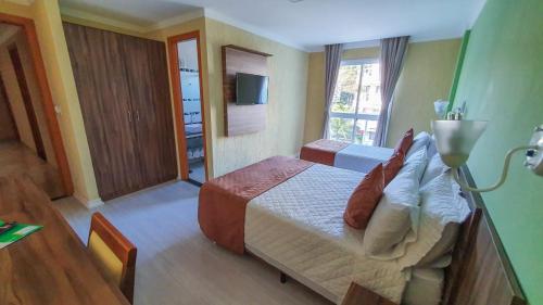 曼加拉蒂巴Pousada Reserva do Sahy的酒店客房,配有床和电视