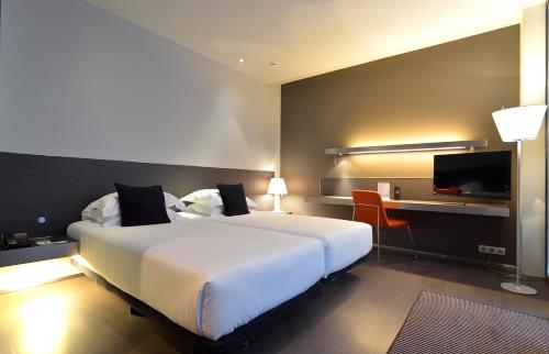巴塞罗那苏荷酒店的酒店客房设有一张白色大床和一张书桌