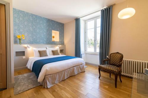 普瓦捷Clos des Moulins的卧室配有床、椅子和窗户。