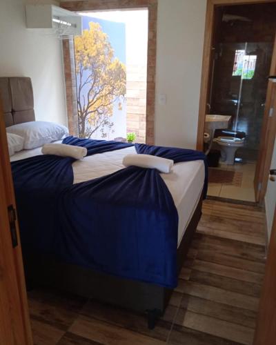 沙帕达-杜斯吉马朗伊斯Pousada Lótus的一间卧室配有一张带蓝色床单的大床