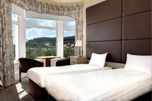 达农SGE Esplanade Hotel的配有大窗户的酒店客房内的两张床
