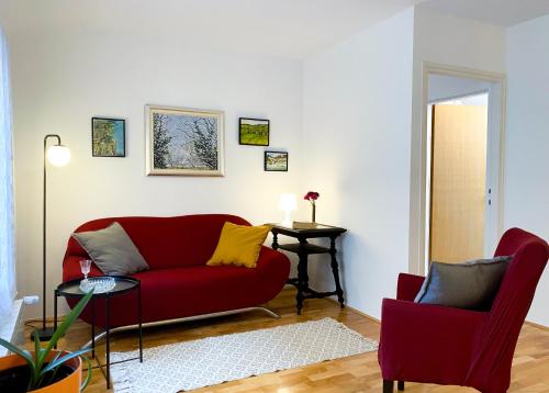 萨格勒布Apartment Mletačka的客厅配有红色的沙发和两把椅子