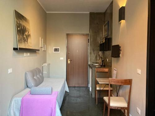 米兰卡吕普索酒店的小房间设有一张床、一张桌子和椅子