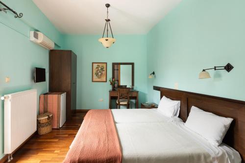 古迈尼萨季莫斯塞尼斯酒店的一间卧室配有一张床和一张书桌