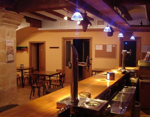 CerolleraHostal La Cerollera的餐厅内的酒吧配有桌椅