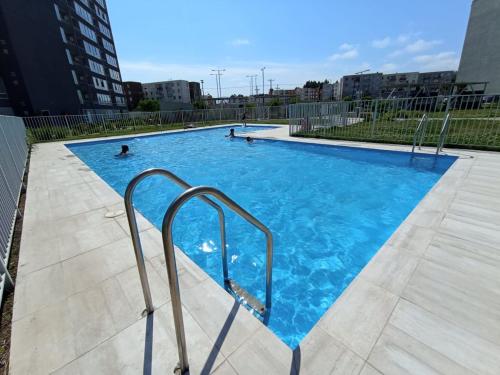 拉塞雷纳Hermoso departamento con piscina, muy cerca del centro, playas, malls, hipermercado, hospital y clínicas的一座蓝色海水的大型游泳池