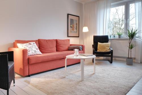 鲁尔河畔米尔海姆Schicke & helle Wohnung in Mülheim an der Ruhr的客厅配有红色的沙发和桌子