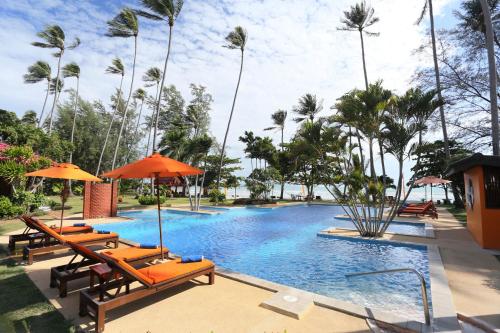 利巴诺伊万岁度假酒店的一个带椅子和遮阳伞的游泳池以及棕榈树