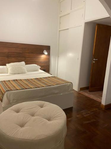 马德普拉塔Espacio C的一间卧室配有两张床和一张搁脚凳