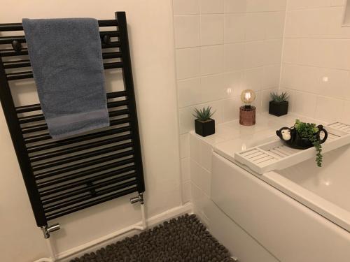 科尔切斯特The Velveteen Townhouse的浴室配有带植物和毛巾的浴缸。