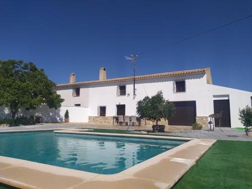 卡斯特里尔Cortijos Rurales Castril, El Casto的白色房子前的游泳池