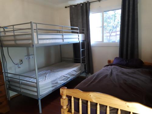圣安娜OC House的一间卧室配有两张双层床和一张床