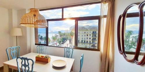 马拉加Panoramic views to the sea in Malaga的一间带桌椅和窗户的用餐室