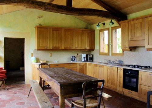 Saint-CybranetMaison de 4 chambres avec piscine partagee et jardin amenage a Saint Cybranet的厨房配有木制橱柜和木桌。