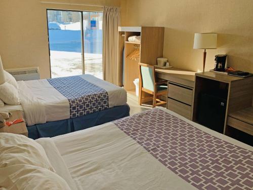 魁北克市Econo Lodge Airport Quebec的酒店客房配有两张床和一张书桌