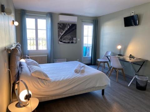 阿让Relais des Iles chambres d'hôtes的卧室配有一张床和一张桌子及椅子