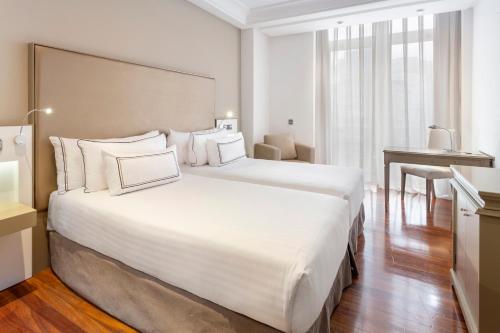 拉科鲁尼亚玛利亚皮塔美利亚酒店的酒店客房设有一张白色大床和一张桌子。
