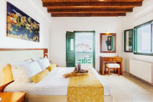 阿斯提帕莱亚镇安德罗梅塔度假酒店的卧室配有一张床、一张书桌和窗户。