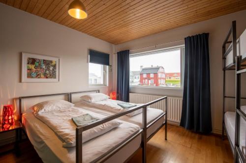 斯蒂克松鲁姆Sjávarborg的一间卧室设有一张床和一个大窗户