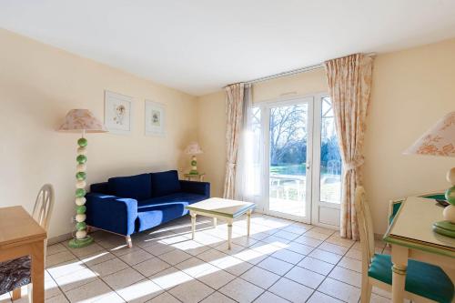 弗代纳渣油格兰德阿维农高尔夫酒店的客厅配有蓝色的沙发和桌子