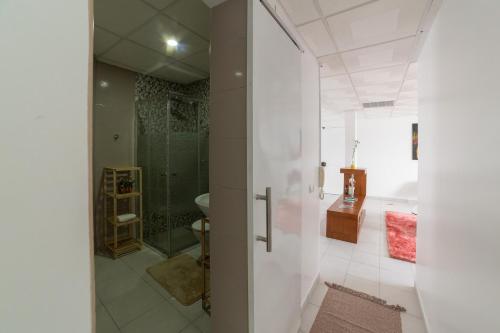 普拉亚A Casa da Mizi的带淋浴和盥洗盆的白色浴室