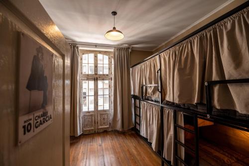 布宜诺斯艾利斯Che Juan Hostel BA的一间设有窗户和窗帘的门的房间