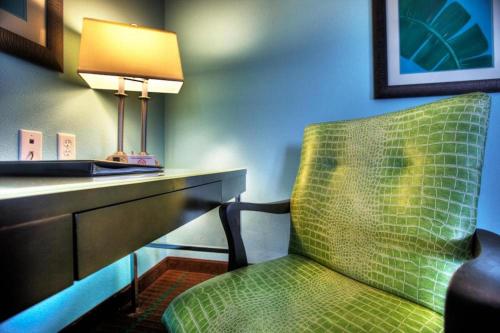 奥卡拉假日酒店及套房奥卡拉会议中心的配有绿色椅子和台灯的书桌的房间