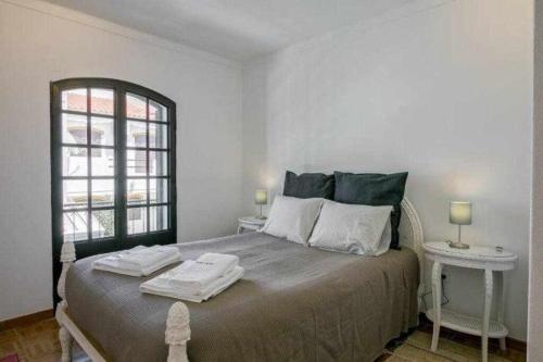 阿尔图拉Vila com piscina e jardim privado的一间卧室配有一张大床和两张桌子