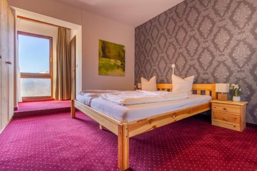 SulzHotel Pension Löwen in Sulz的一间卧室配有一张紫色地毯的床