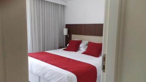 科洛尼亚-德尔萨克拉门托Dpto de 1 dormitorio, 402 Dos Orillas, Colonia的一间卧室配有一张带红色枕头的大床