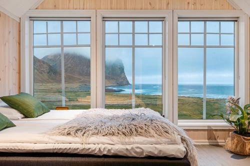 UnnstadUnstad Arctic Resort的一间卧室设有一张床,享有海景